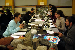 Students using microscopes in lab.