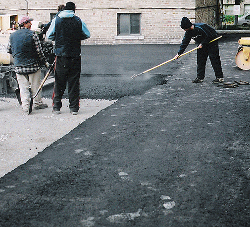 workers paving a road with asphalt